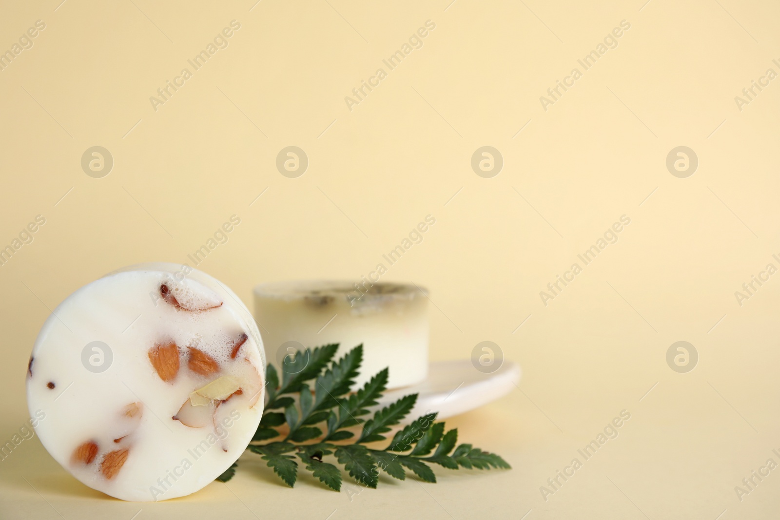 Photo of Soap bars and green leaf on beige background, space for text. Eco friendly personal care product