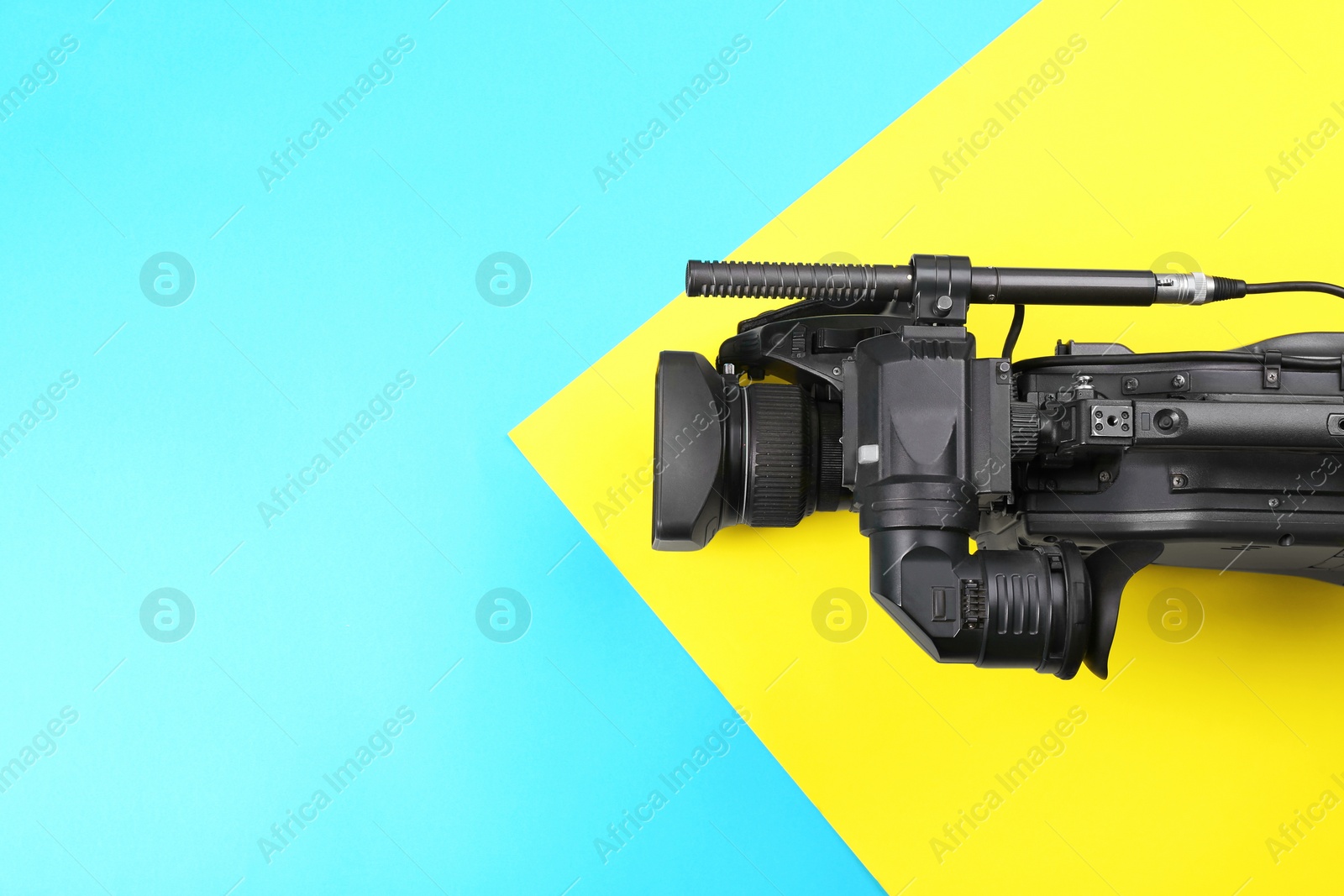 Photo of Modern video camera on color background, top view. Space for text