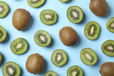 Photo of Top view of fresh whole and cut kiwis on light blue background