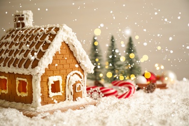 Beautiful gingerbread house decorated with icing on snow, closeup. Space for text