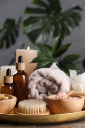 Photo of Spa composition. Pink sea salt, brush and bottles on table