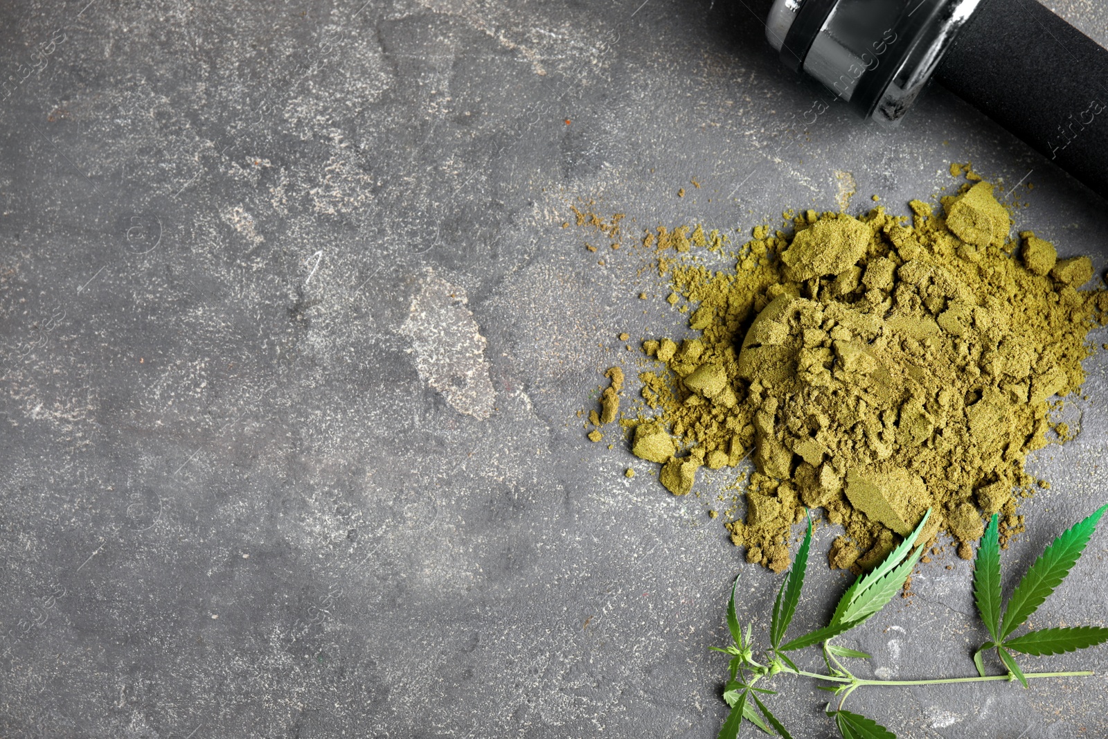 Photo of Hemp protein powder, fresh leaves and dumbbell on grey table, flat lay. Space for text