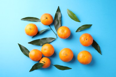 Fresh ripe tangerines on light blue background, flat lay