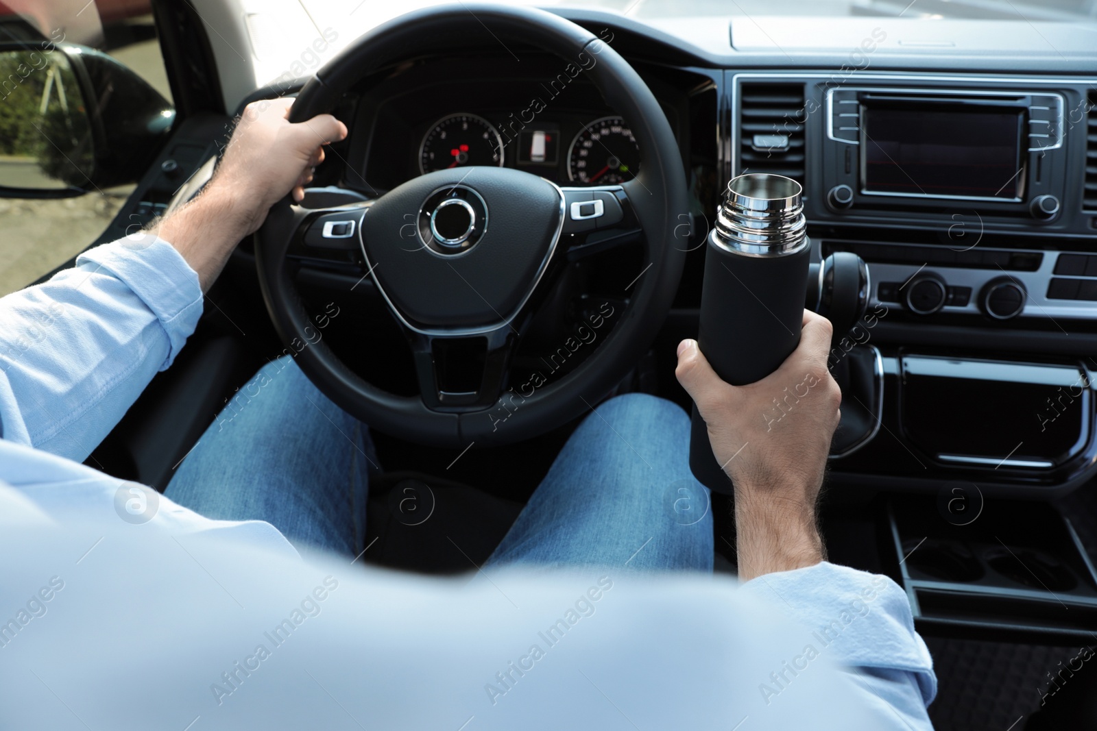 Photo of Man with thermos driving car, closeup view