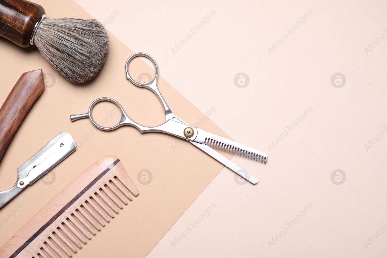 Photo of Set of barber's equipment on beige background, flat lay. Space for text
