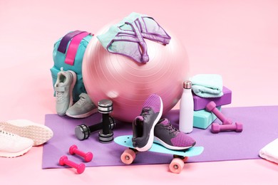 Photo of Many different sports equipment on pink background