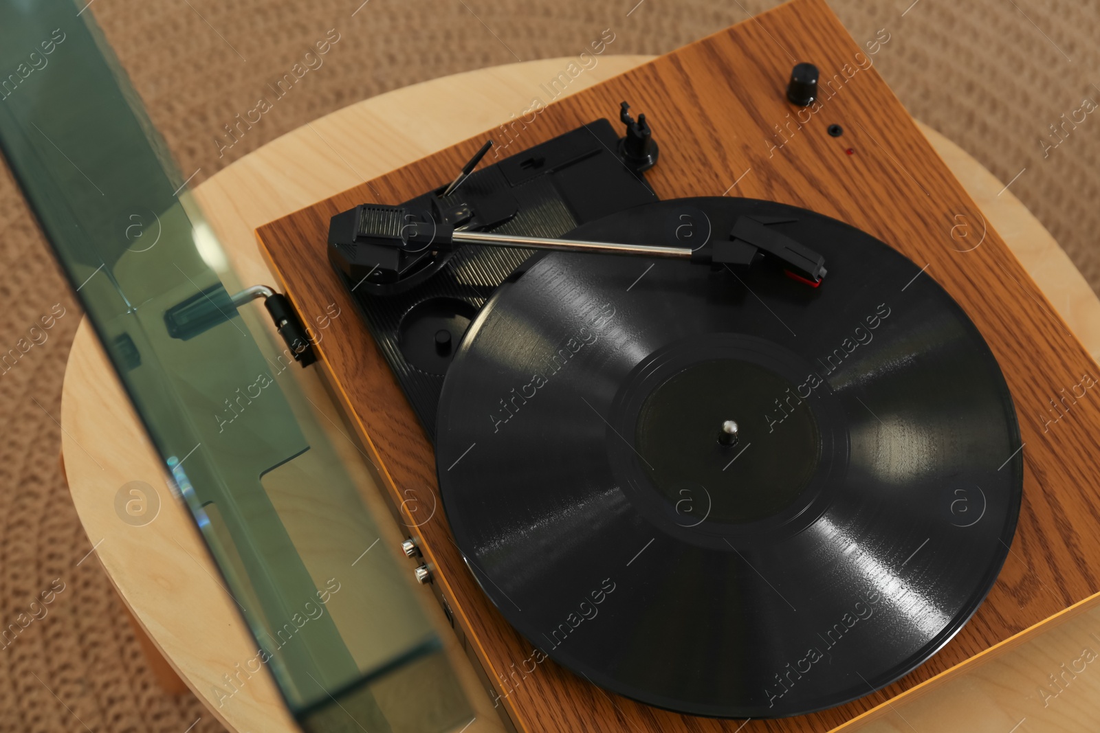 Photo of Modern vinyl record player with disc on table indoors