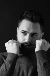 Photo of Portrait of handsome bearded man on dark background. Black and white effect