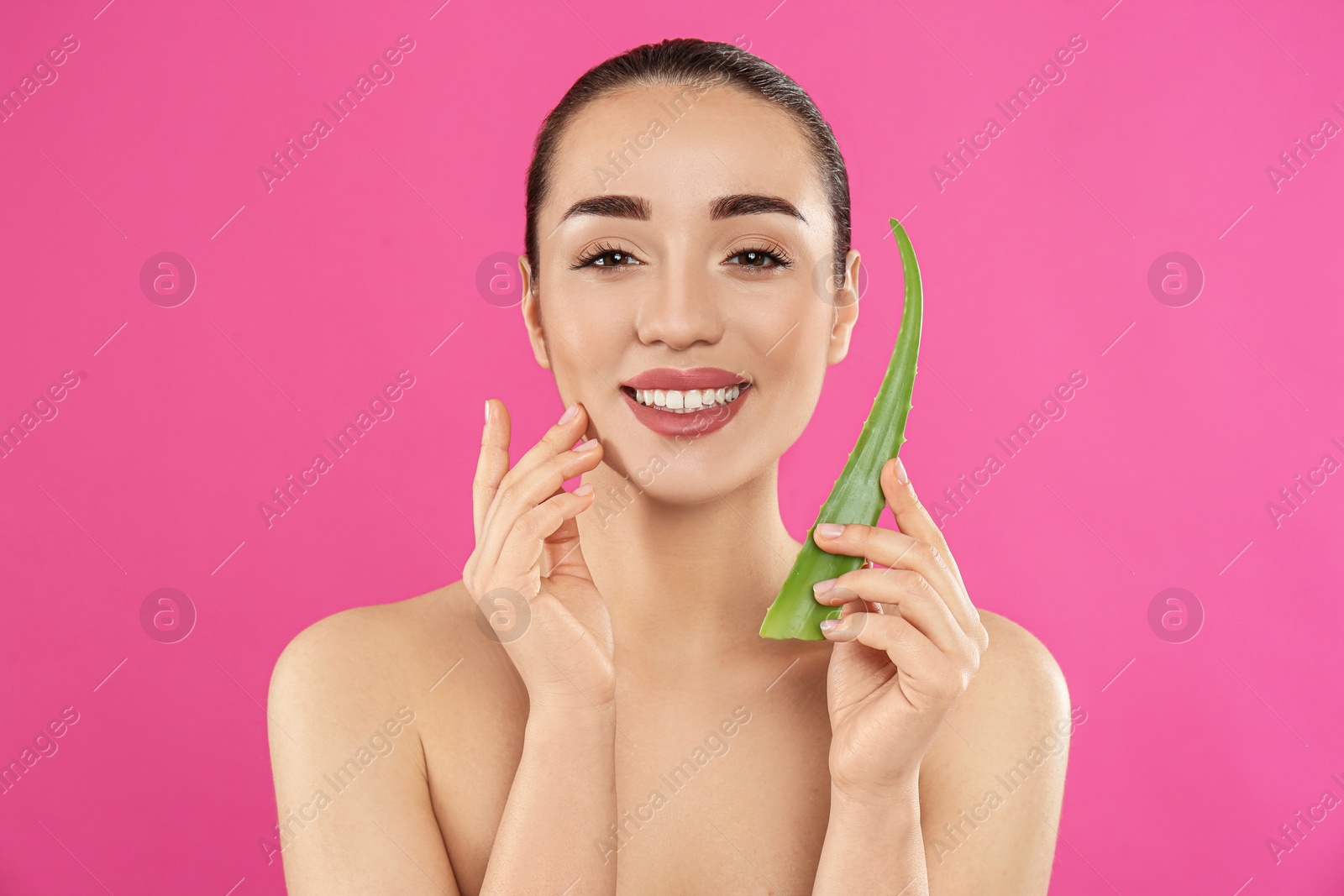 Photo of Young woman with aloe vera leaf on pink background