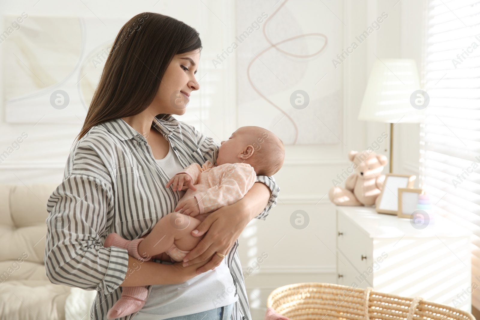 Photo of Mother holding her sleeping baby at home