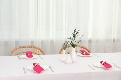 Photo of Beautiful table setting and vases with green branches in dining room