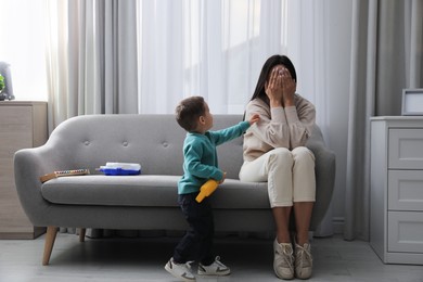 Photo of Depressed single mother with child in living room
