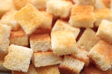 Photo of Delicious crispy croutons as background, closeup view
