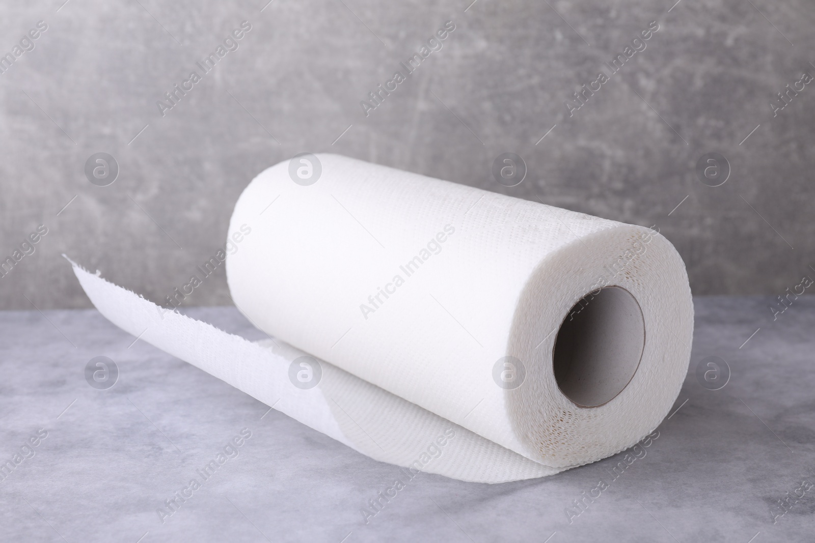 Photo of One roll of paper towels on grey table, closeup