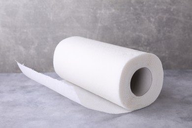 Photo of One roll of paper towels on grey table, closeup