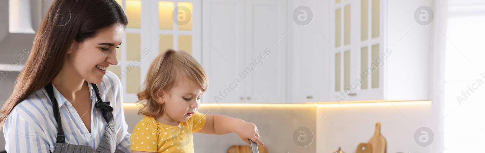 Image of Mother and her little daughter cooking together in kitchen, space for text. Banner design