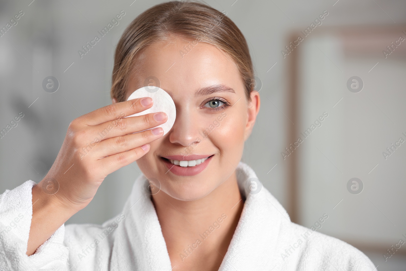 Photo of Beautiful young woman with cotton pad indoors