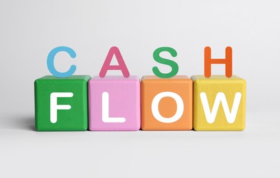 Phrase Cash Flow made with letters and colorful cubes on white background