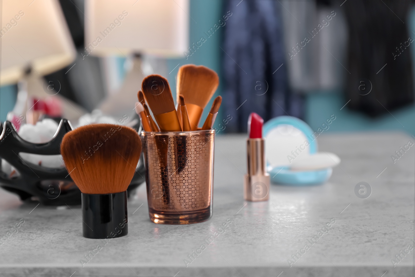 Photo of Brushes on dressing table in makeup room, closeup