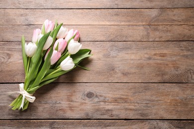 Photo of Beautiful pink spring tulips on wooden background, top view. Space for text