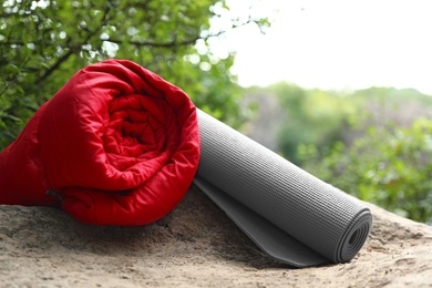 Photo of Rolled sleeping bag and mat on rock