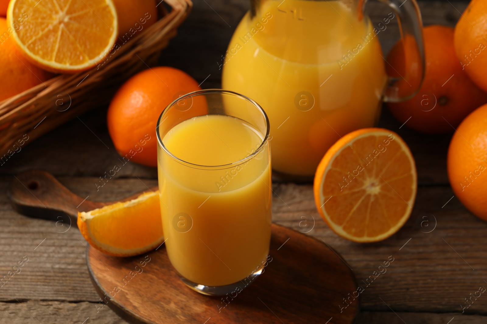Photo of Tasty fresh oranges and juice on wooden table, closeup