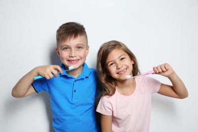 Photo of Portrait of cute children with toothbrushes on white background