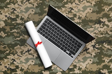 Photo of Laptop and diploma on camouflage background, top view. Military education