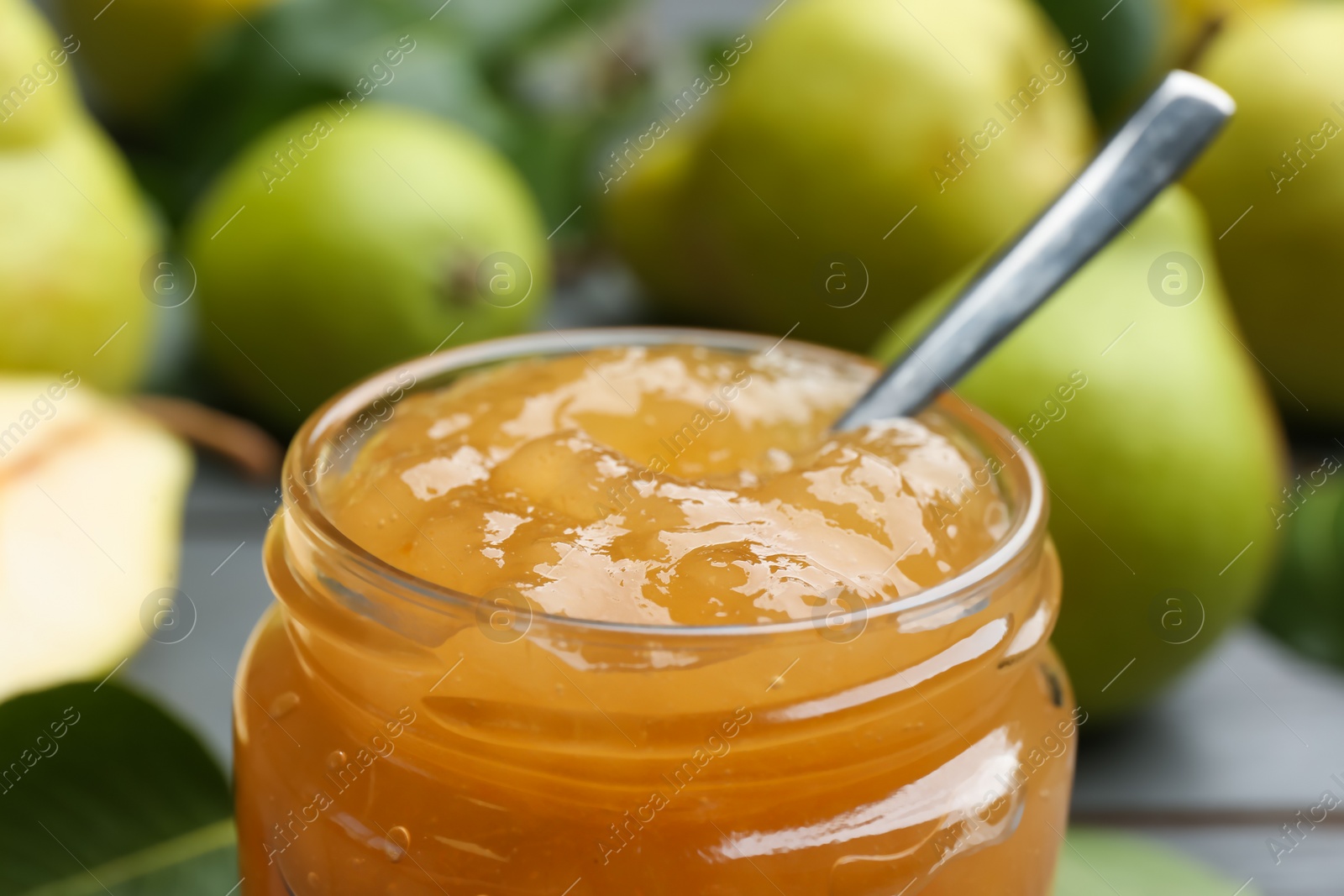 Photo of Delicious pear jam in glass jar, closeup