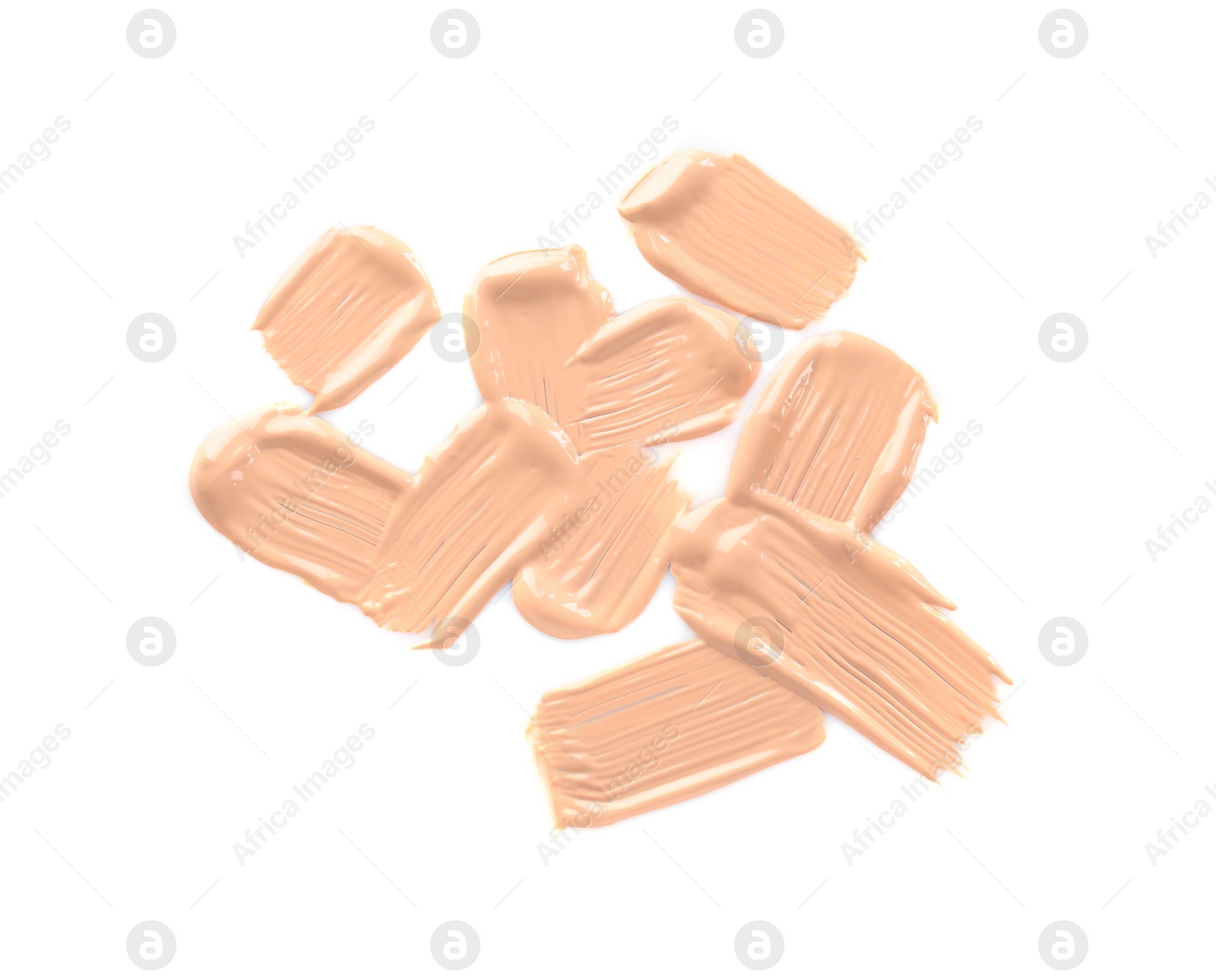 Photo of Strokes of liquid foundation on white background, top view