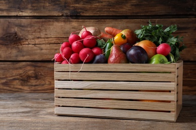 Photo of Crate full of different vegetables and fruits on wooden table. Harvesting time