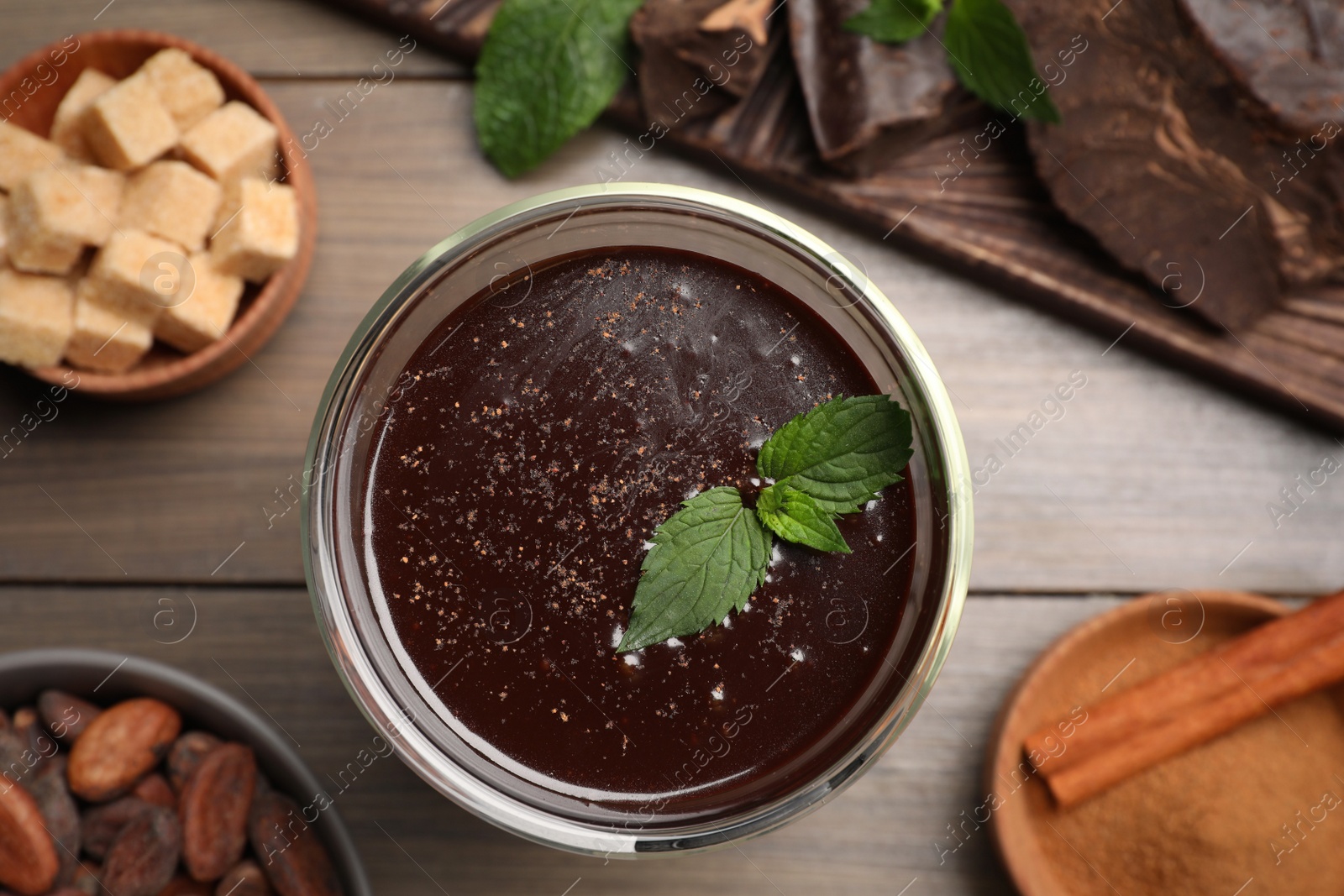 Photo of Glass of delicious hot chocolate with fresh mint on wooden table, flat lay