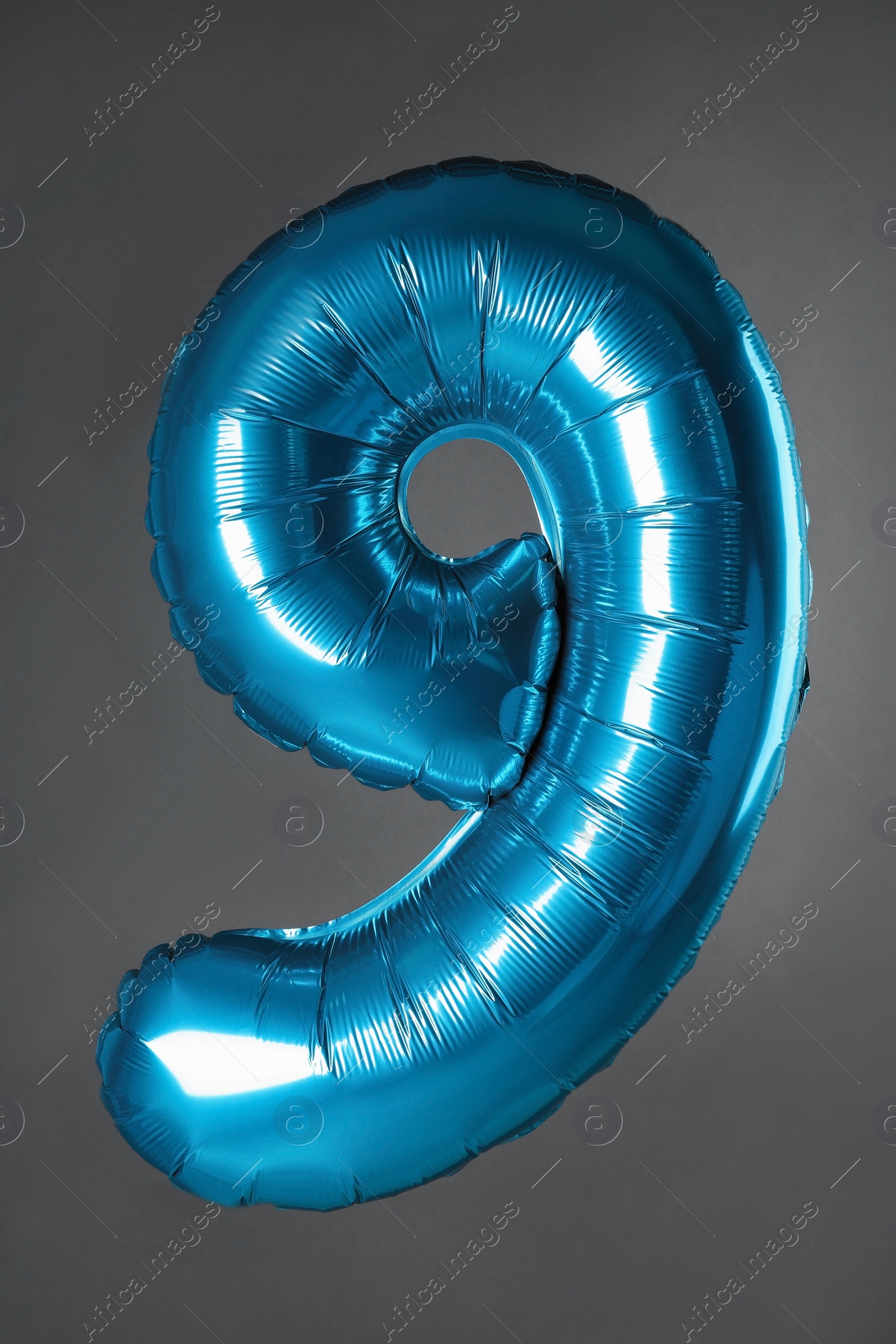 Photo of Blue number nine balloon on grey background