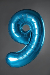 Blue number nine balloon on grey background