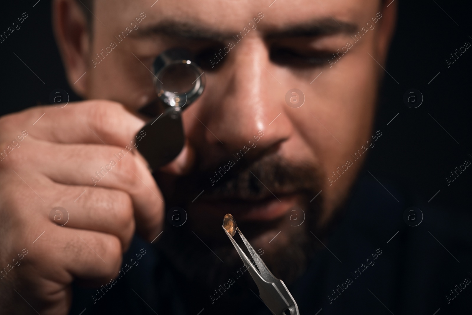 Photo of Professional jeweler working with gemstone, closeup view