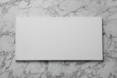Photo of Blank canvas on white marble background, space for text