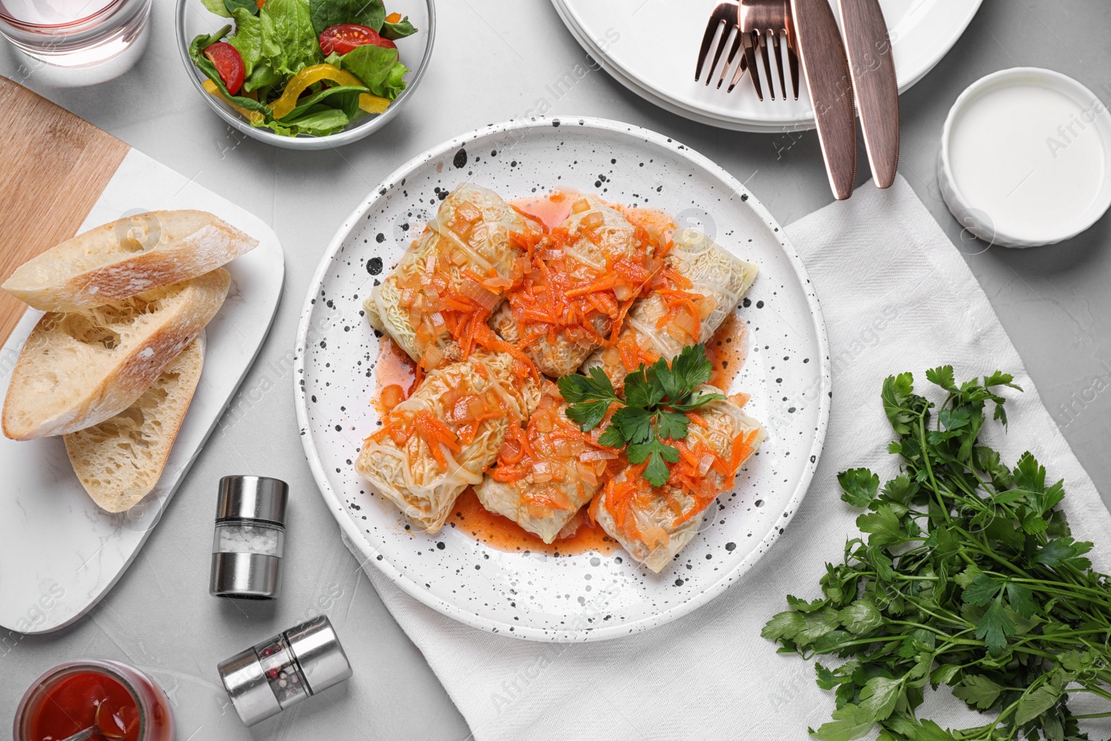 Photo of Delicious cabbage rolls served on grey table, flat lay