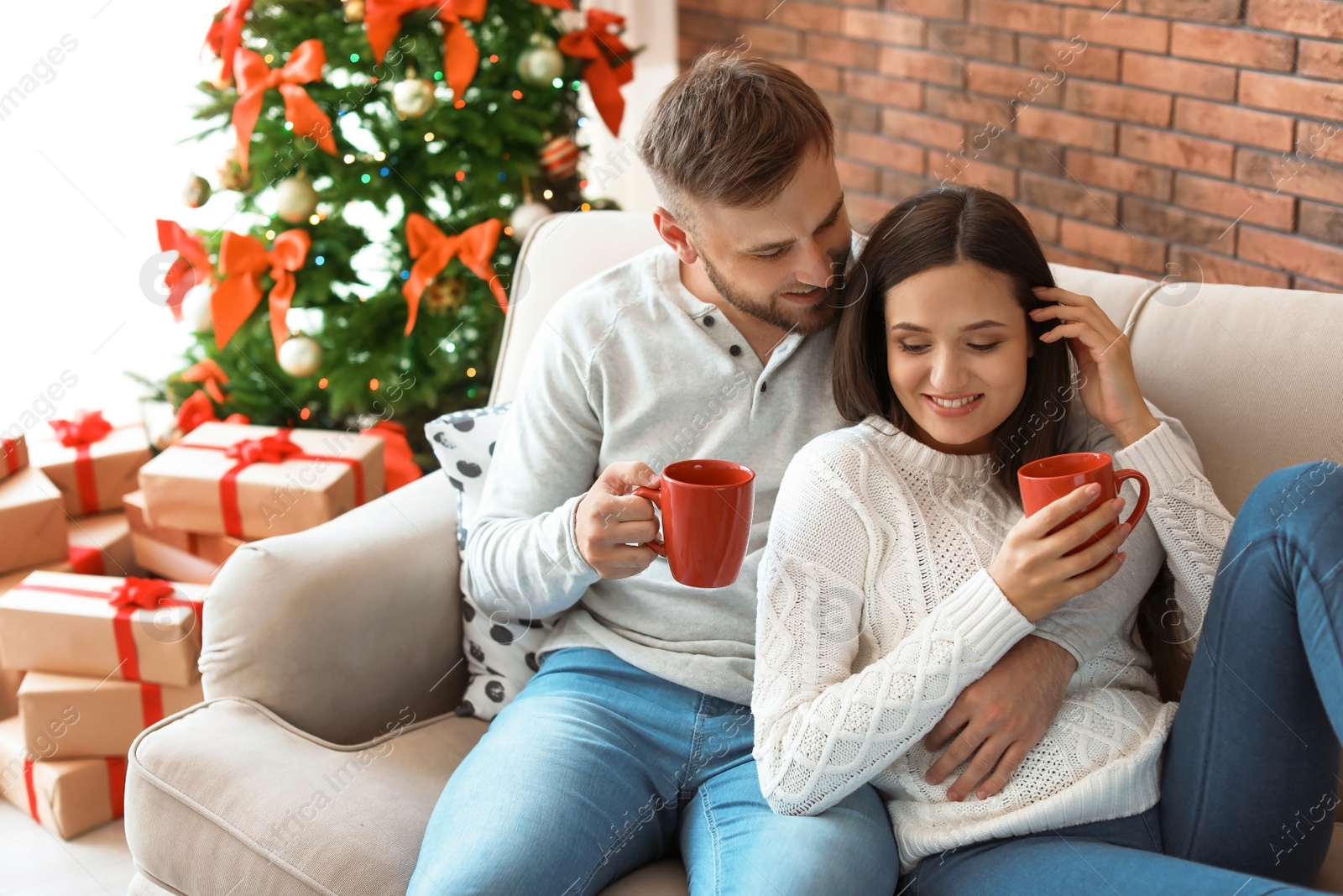 Photo of Happy young couple celebrating Christmas at home