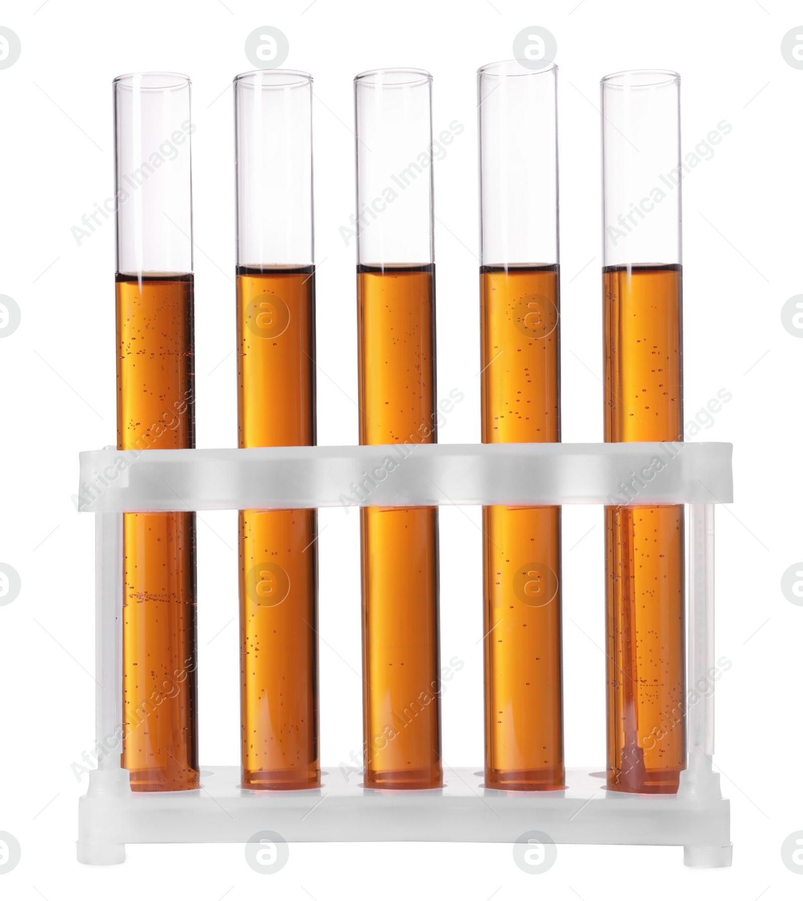 Photo of Test tubes with brown liquid in stand on white background