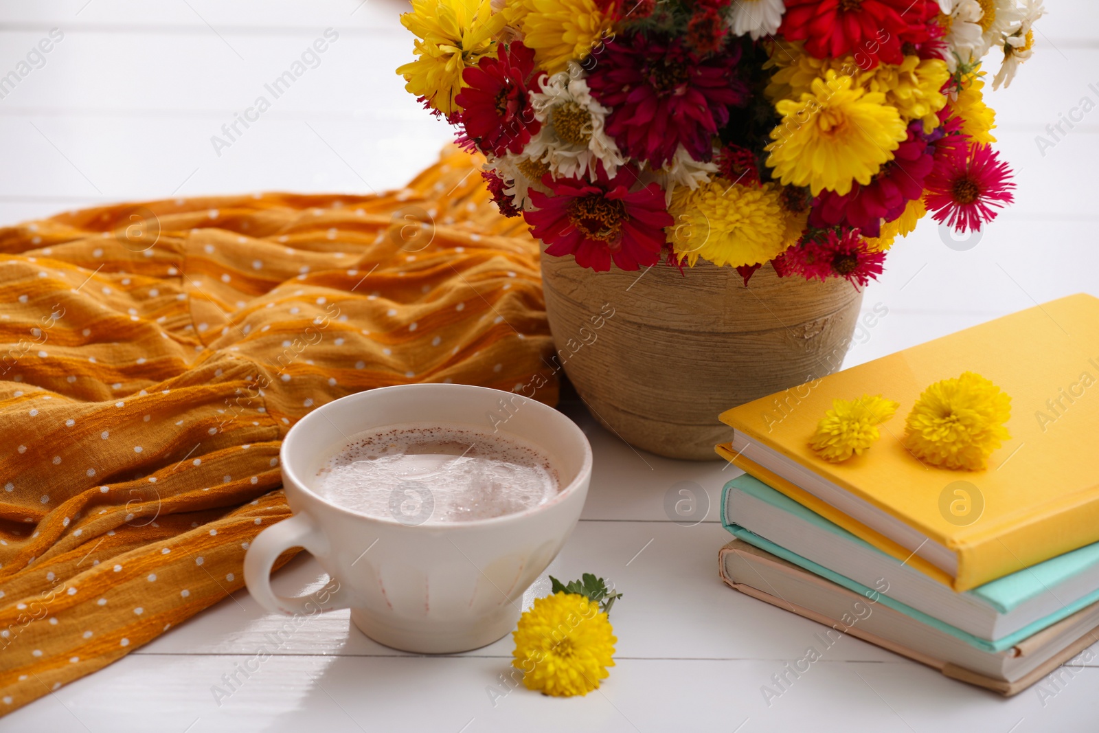 Photo of Cup of fresh coffee, books and beautiful bouquet on white wooden table. Good morning