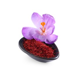 Dried saffron and crocus flower in bowl on white background