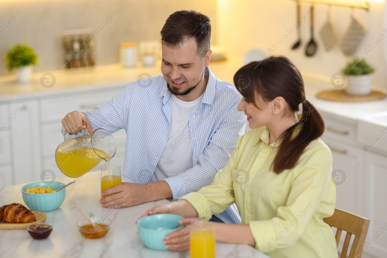 Photo of Happy couple having tasty breakfast at home