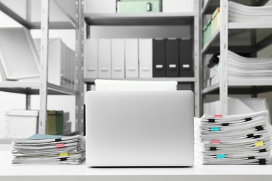 Laptop and documents on desk in office