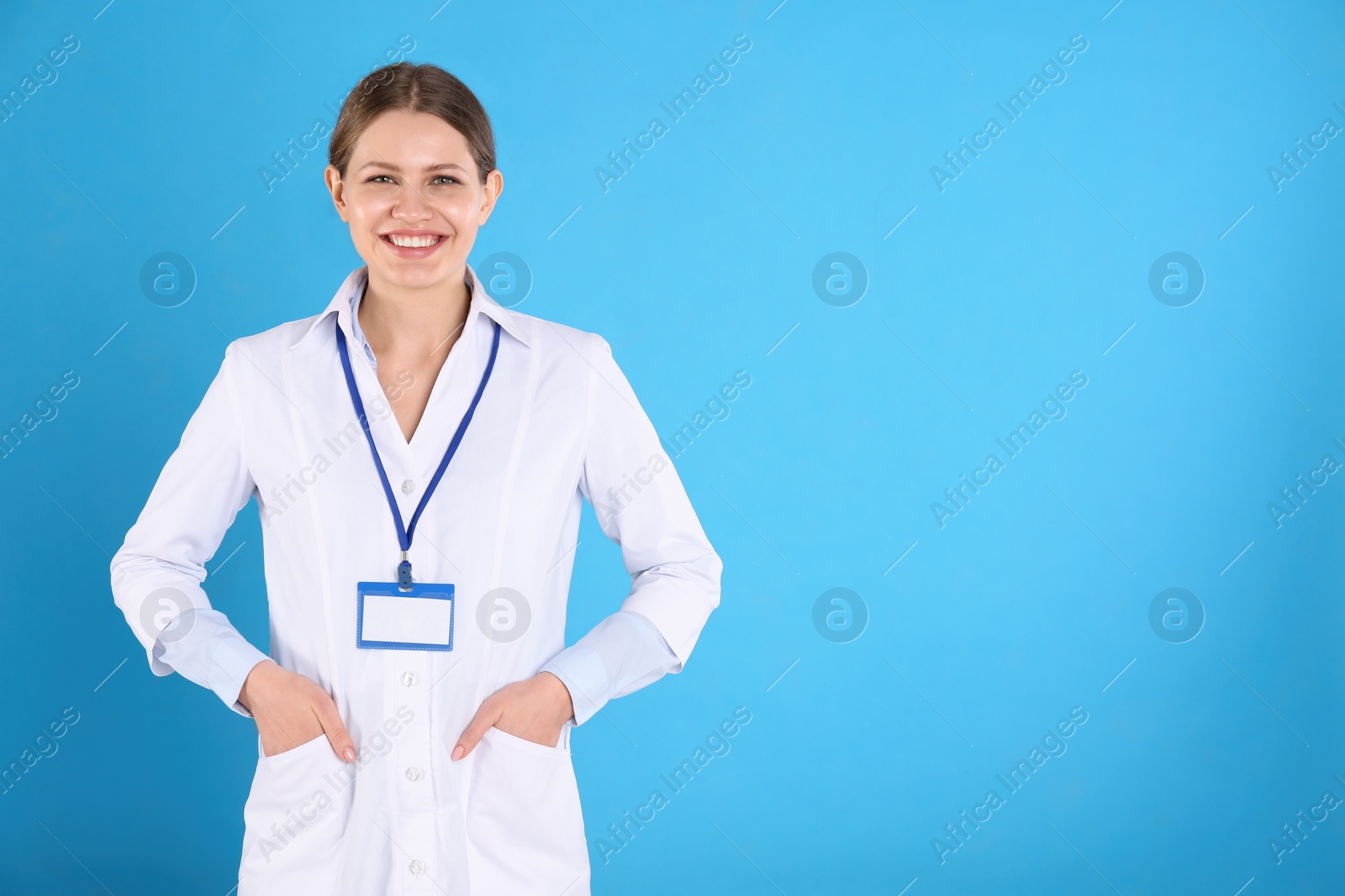 Photo of Portrait of young doctor on blue background, space for text