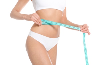 Photo of Slim young woman with smooth gentle skin in underwear measuring body on white background, closeup