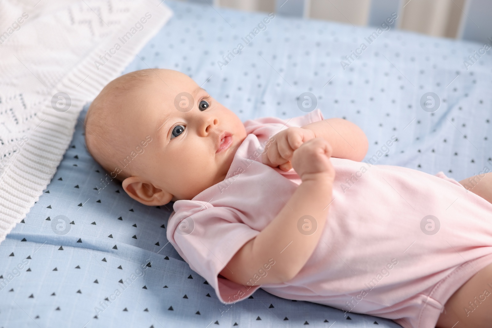 Photo of Cute little baby lying in crib at home