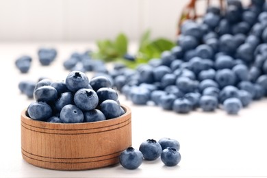 Photo of Tasty fresh blueberries on white table, closeup. Space for text