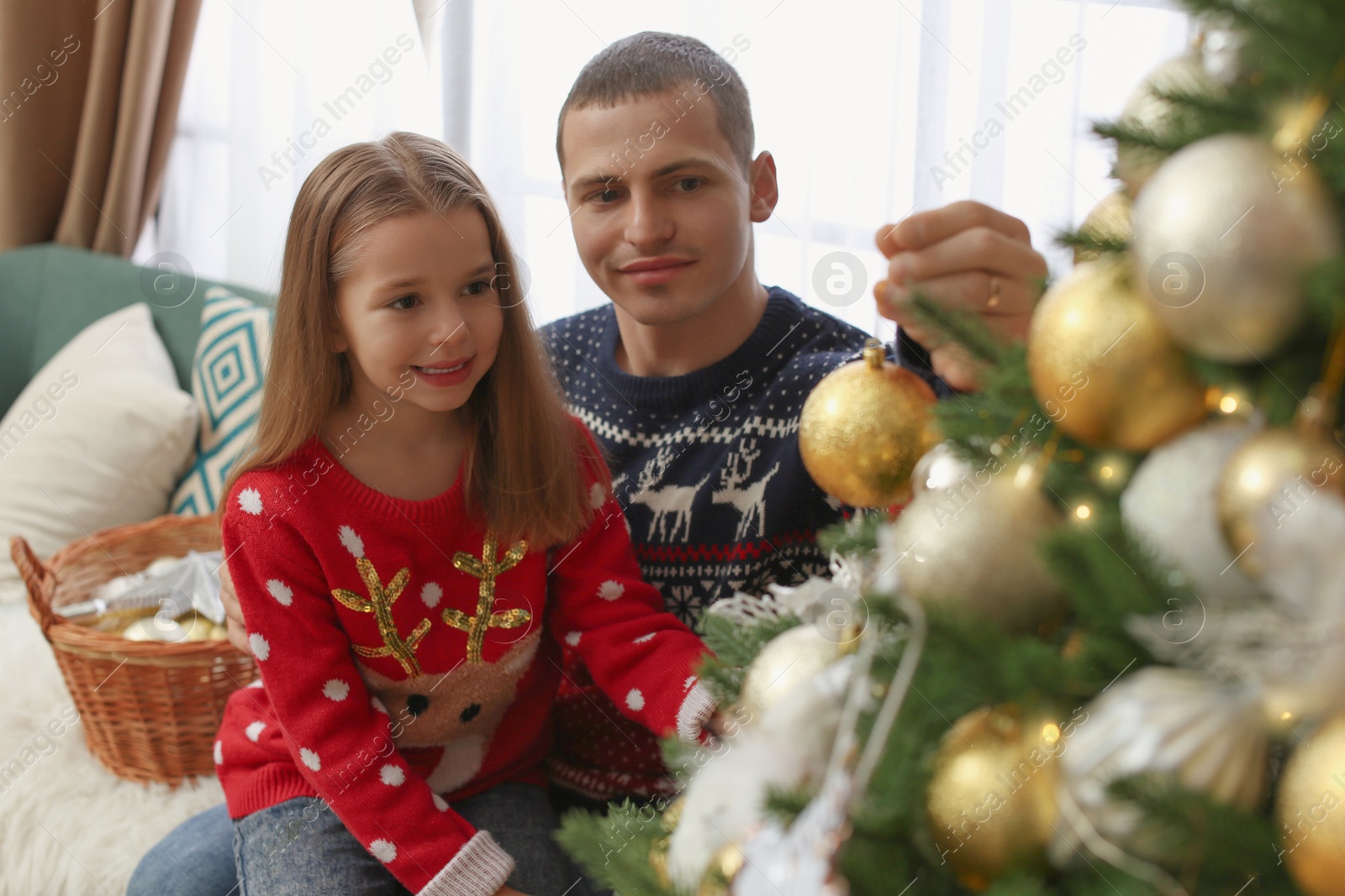 Photo of Father with daughter decorating Christmas tree at home
