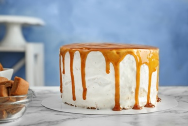 Delicious homemade cake with caramel sauce on table