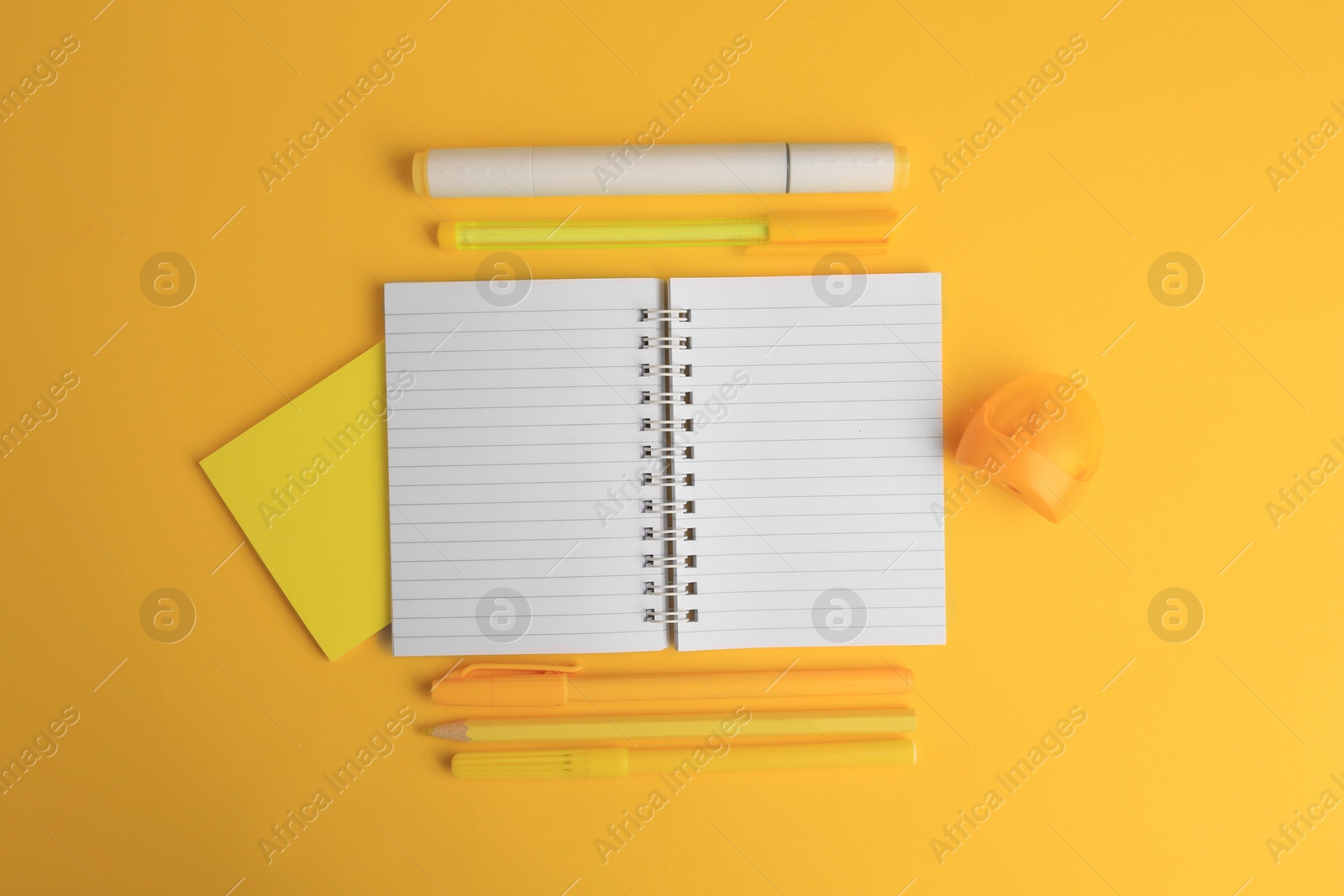 Photo of Flat lay composition with open notebook and different school stationery on yellow background, space for text. Back to school